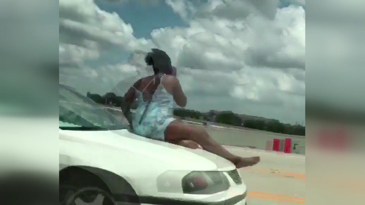 Women tied on the hood of a car